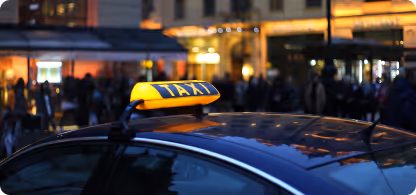 Enseigne lumineuse jaune de taxi sur le toit d'une voiture avec des passants flous en arrière-plan.