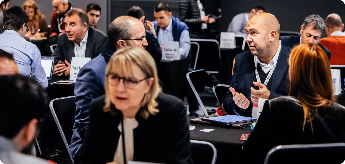 Des professionnels discutent et échangent lors d'une réunion en groupe dans une salle de conférence.