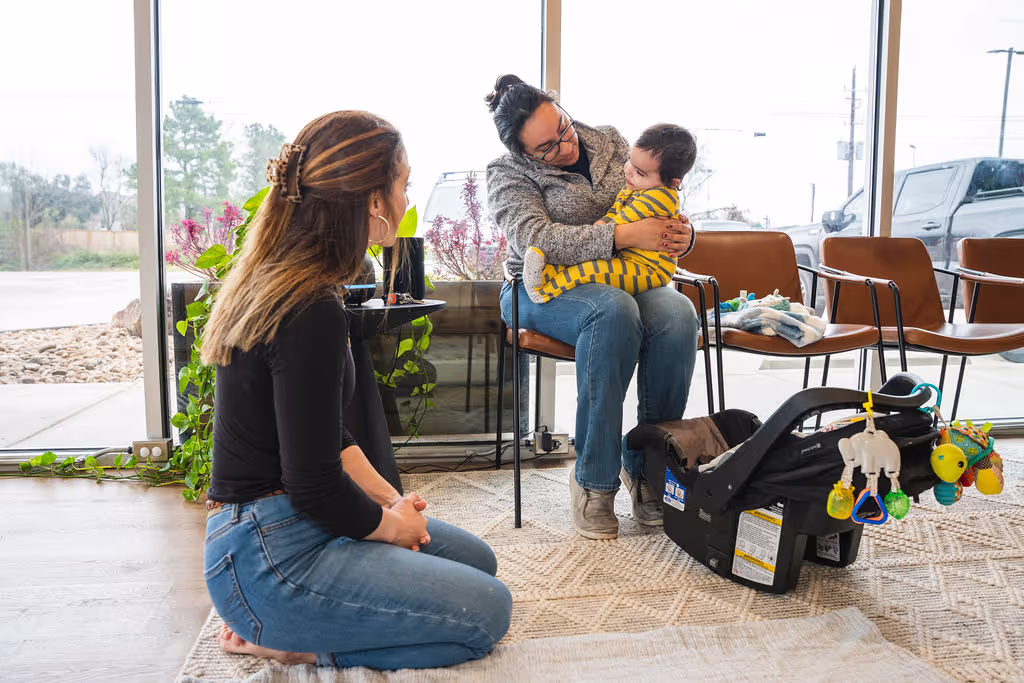 Mom holding baby with family chiropractor providing gentle infant care