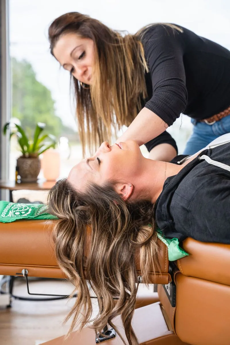 Female chiropractor performing gentle adjustment on woman for nervous system care