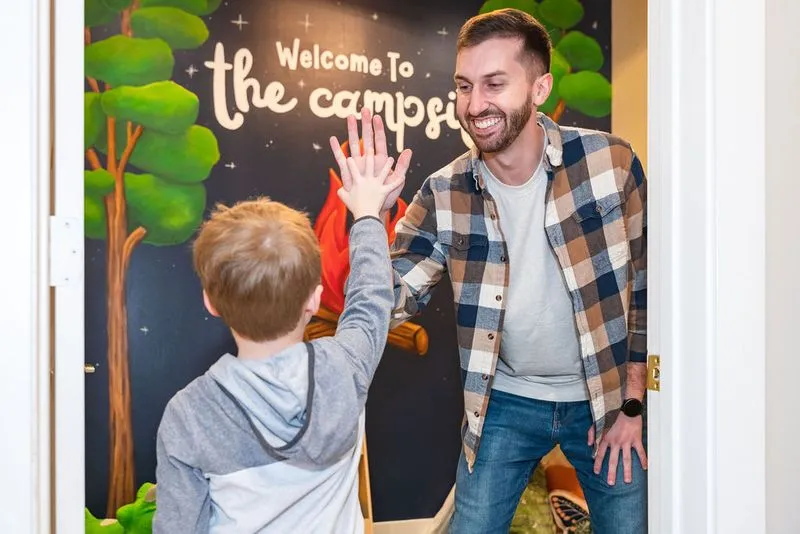 Man high-fiving child at Ignite Chiropractic pediatric-friendly office