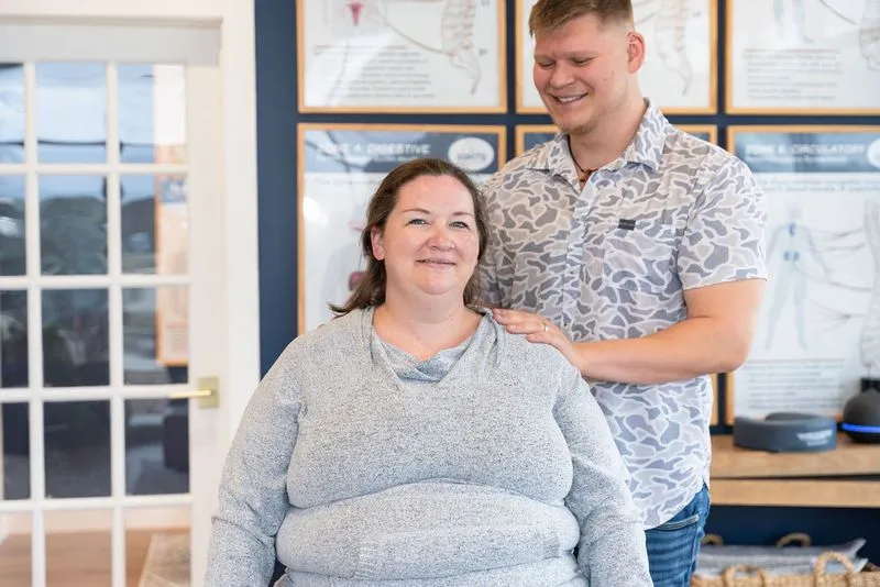 Smiling pregnant woman being examined by chiropractor for prenatal care