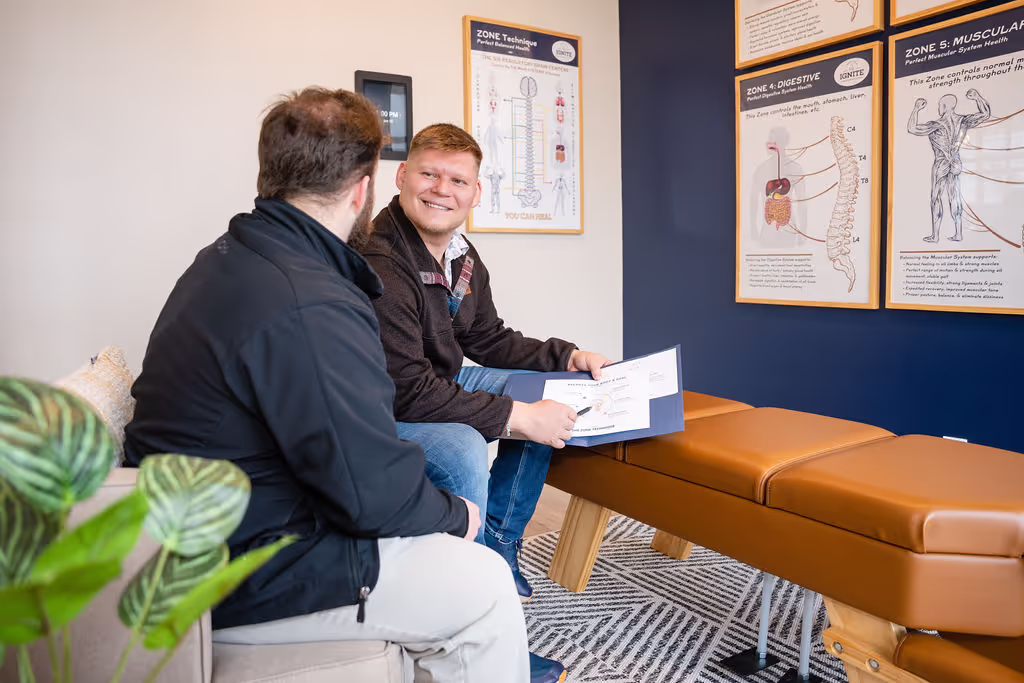 Chiropractor discussing Zone Technique care plan with patient at Ignite