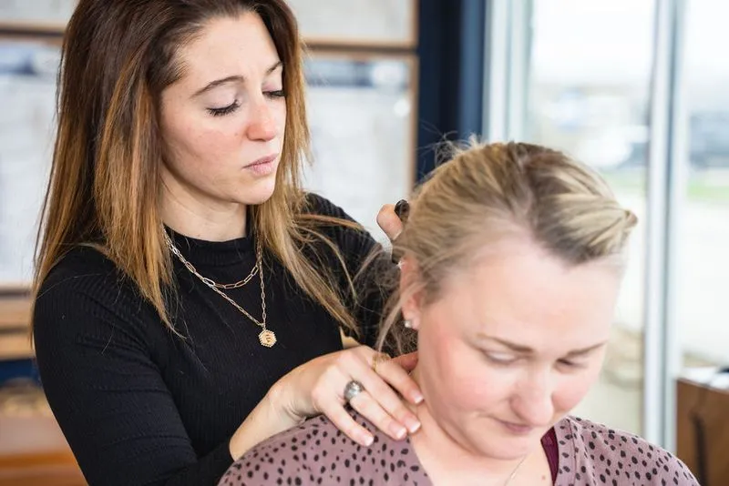Female chiropractor using Zone Technique to examine patient's upper cervical spine
