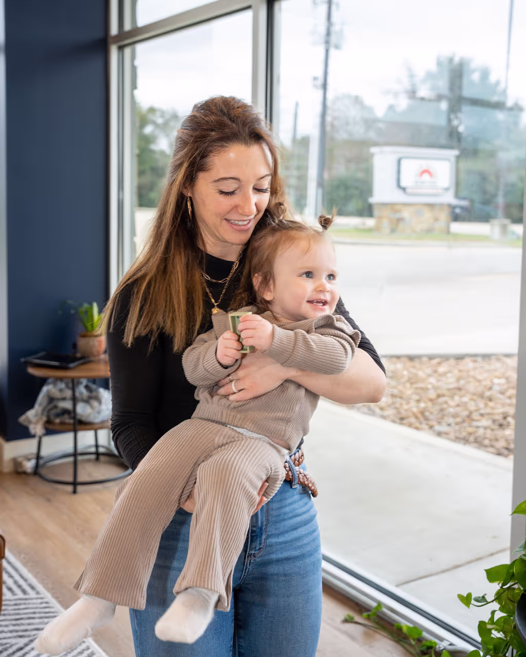 A chiropractor at Ignite Chiropractic near Tomball, TX holds a toddler after providing and adjustment that supported nervous system development.