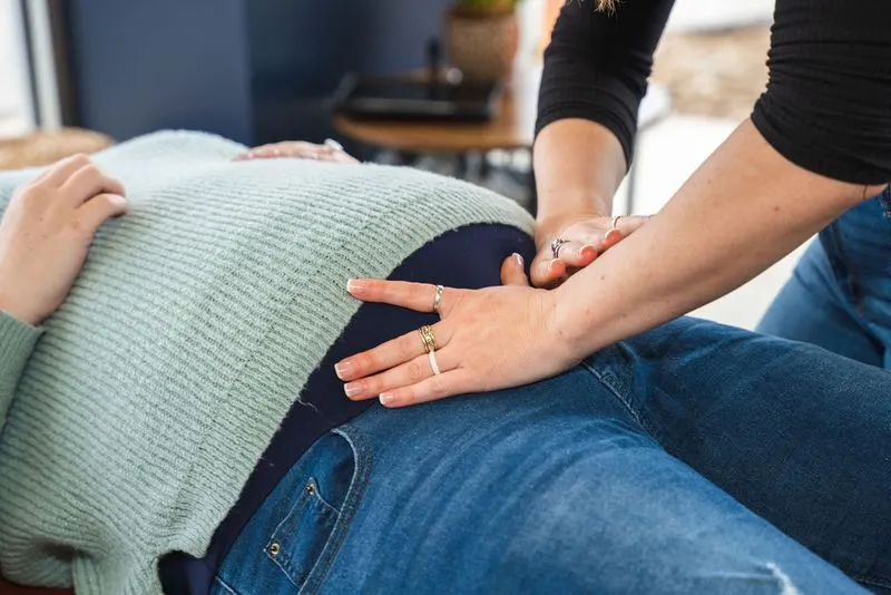 A chiropractor at Ignite Chiropractic performing a gentle prenatal adjustment using the Webster Technique on a pregnant woman to support pelvic alignment, reduce discomfort, and optimize conditions for a comfortable pregnancy and birth.