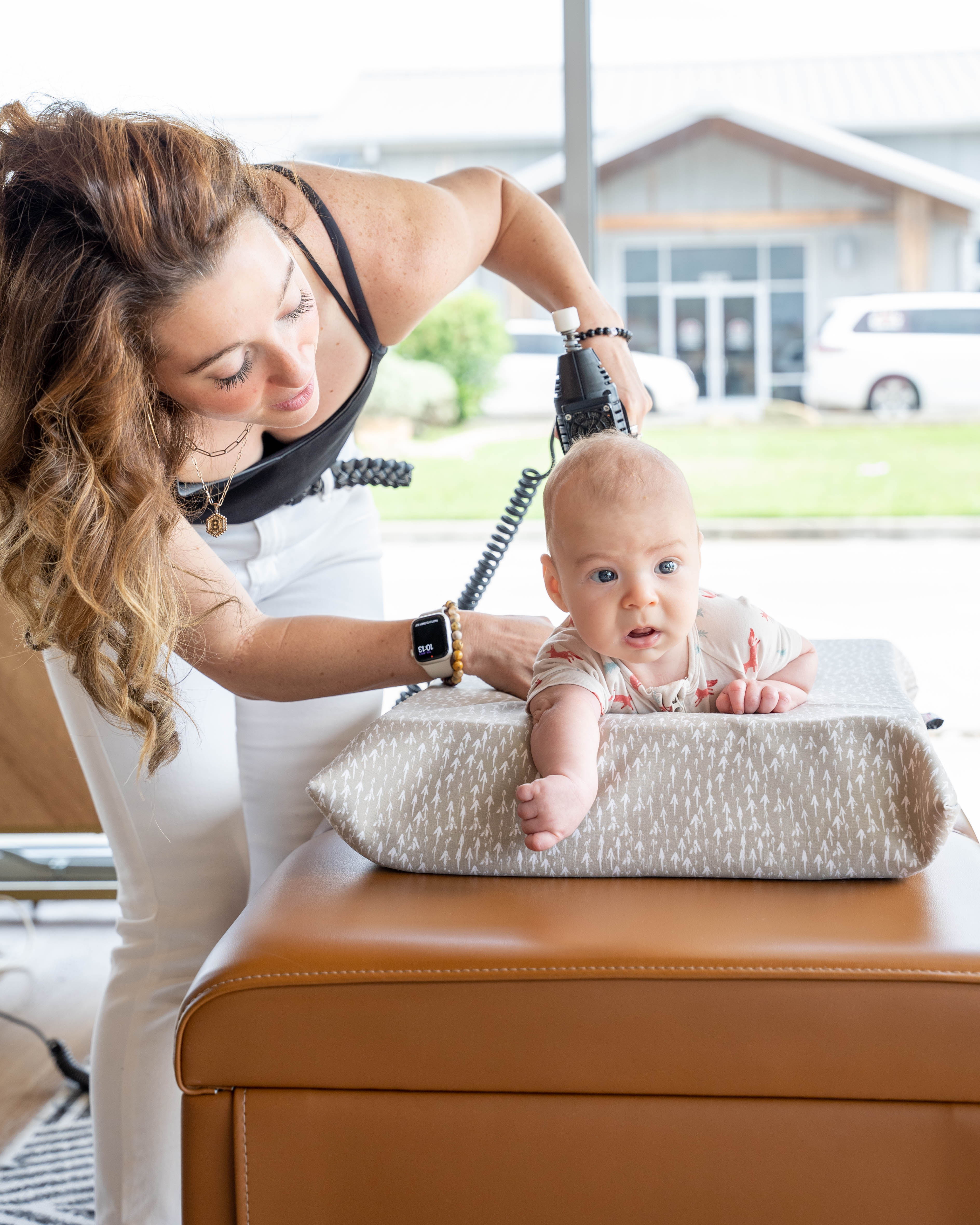 Chiropractor gently adjusting infant in bright clinic, highlighting gentle pediatric and prenatal chiropractic care in Cyp...