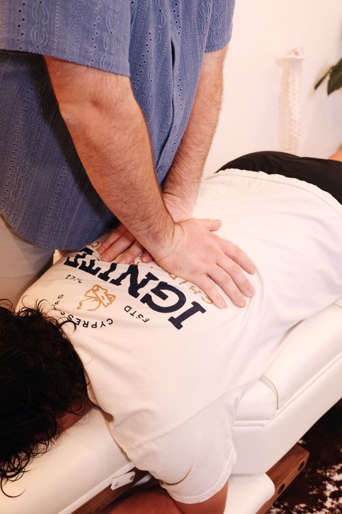 A chiropractor high-fiving a teenager after a chiropractic adjustment near Argyle, TX.