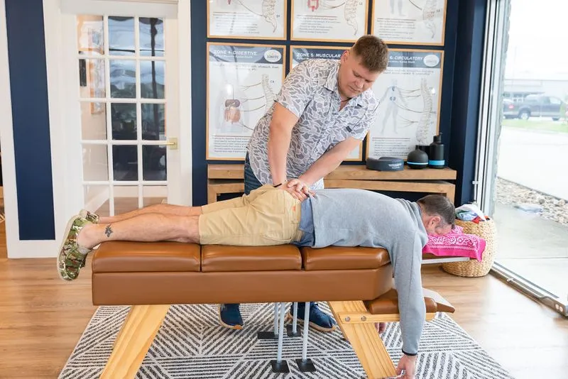 A chiropractor at Ignite Chiropractic gently adjusting a patient’s spine to support sprain and strain recovery, soft tissue healing, and overall mobility.