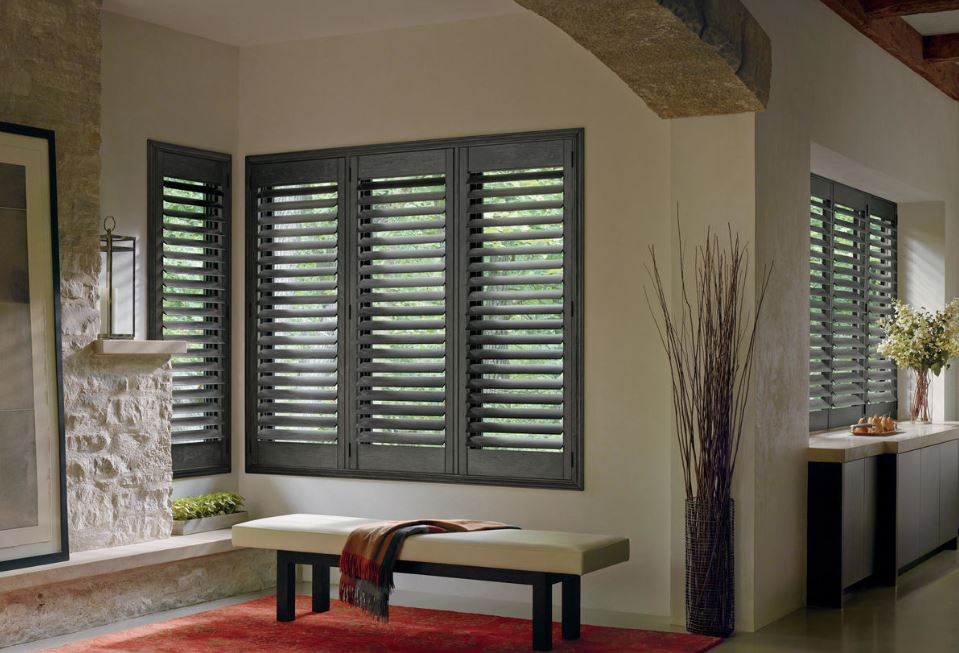 Dark grey window shutters in Reno, NV beautifully installed in a rustic living room corner