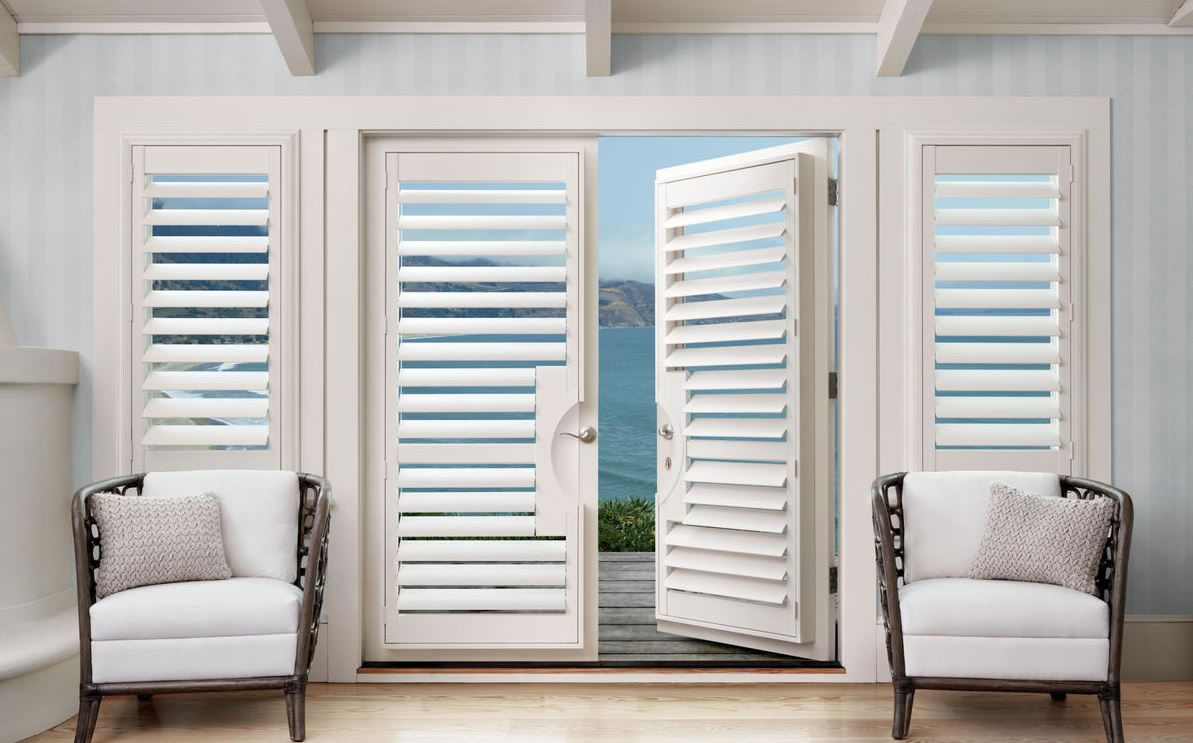 White Truckee, CA window shutters open up to a beautiful ocean view from a living room