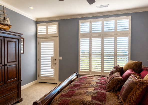 Bedroom featuring window shutters in Sparks, NV with plantation-style panels.
