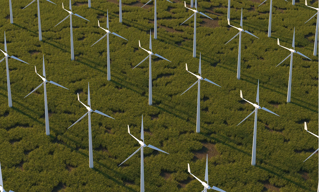 Aerial view of multiple white wind turbines evenly spaced on green grassland casting long shadows.