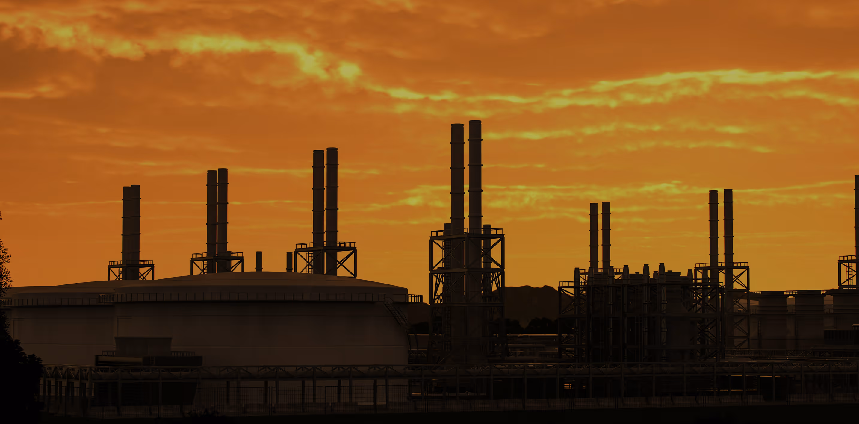 Silhouette of an industrial refinery with multiple smokestacks against an orange sunset sky.