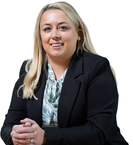 Smiling woman with blonde hair wearing a black blazer and patterned blouse, seated with hands clasped.