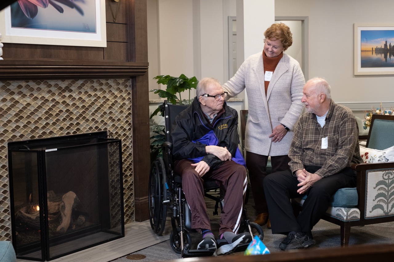 A nursing staff member accompanies a senior Christian Brother at a care facility
