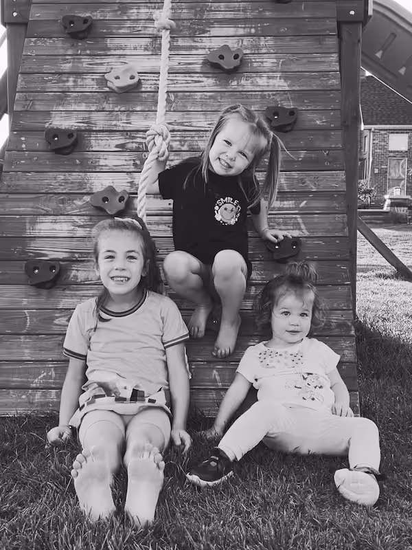 Robert Lopez's daughters on backyard playground equipment.