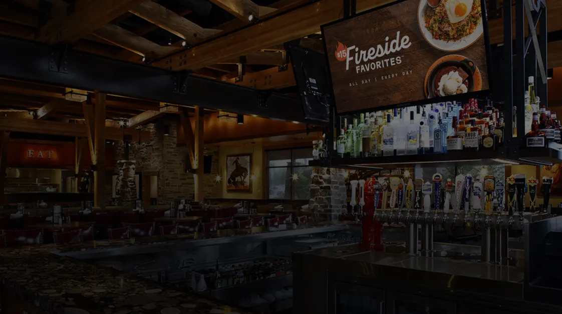 Bar interior with a TV showing a digital menu board