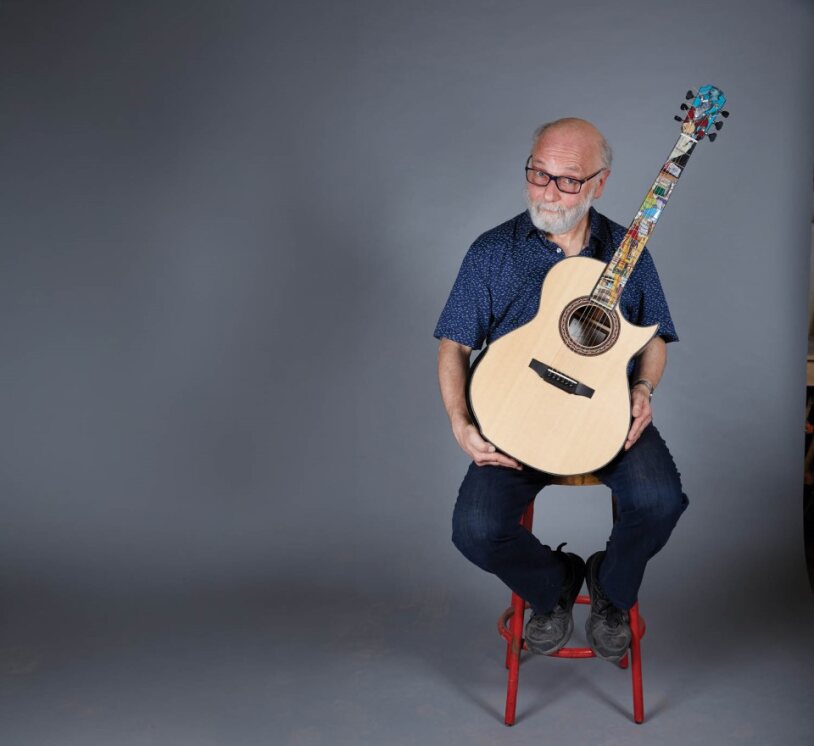 Laskin poses with a guitar in honour of his 50th year as a luthier