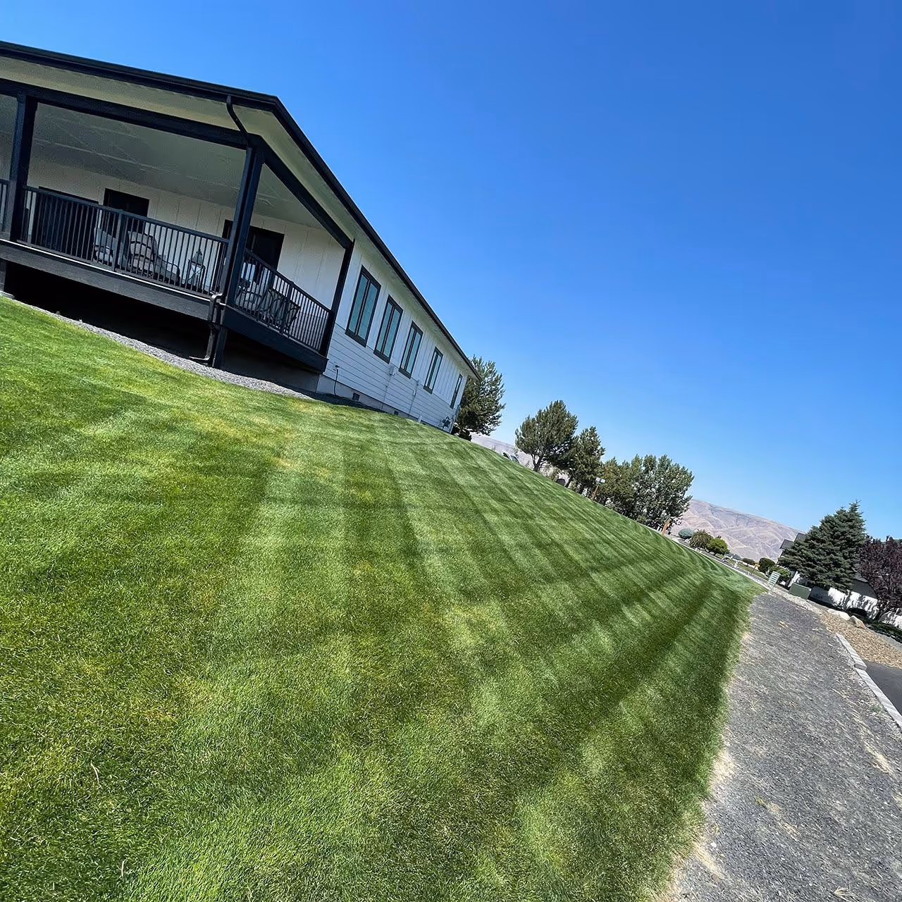 Lawn mowing service on residential property by Two Rivers Lawn Care