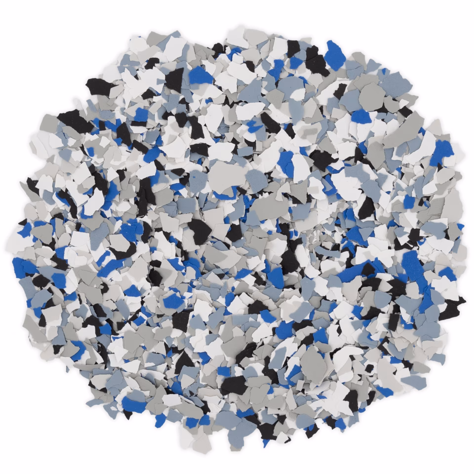 Pile of blue, black, white, and gray decorative floor flakes on a white background.