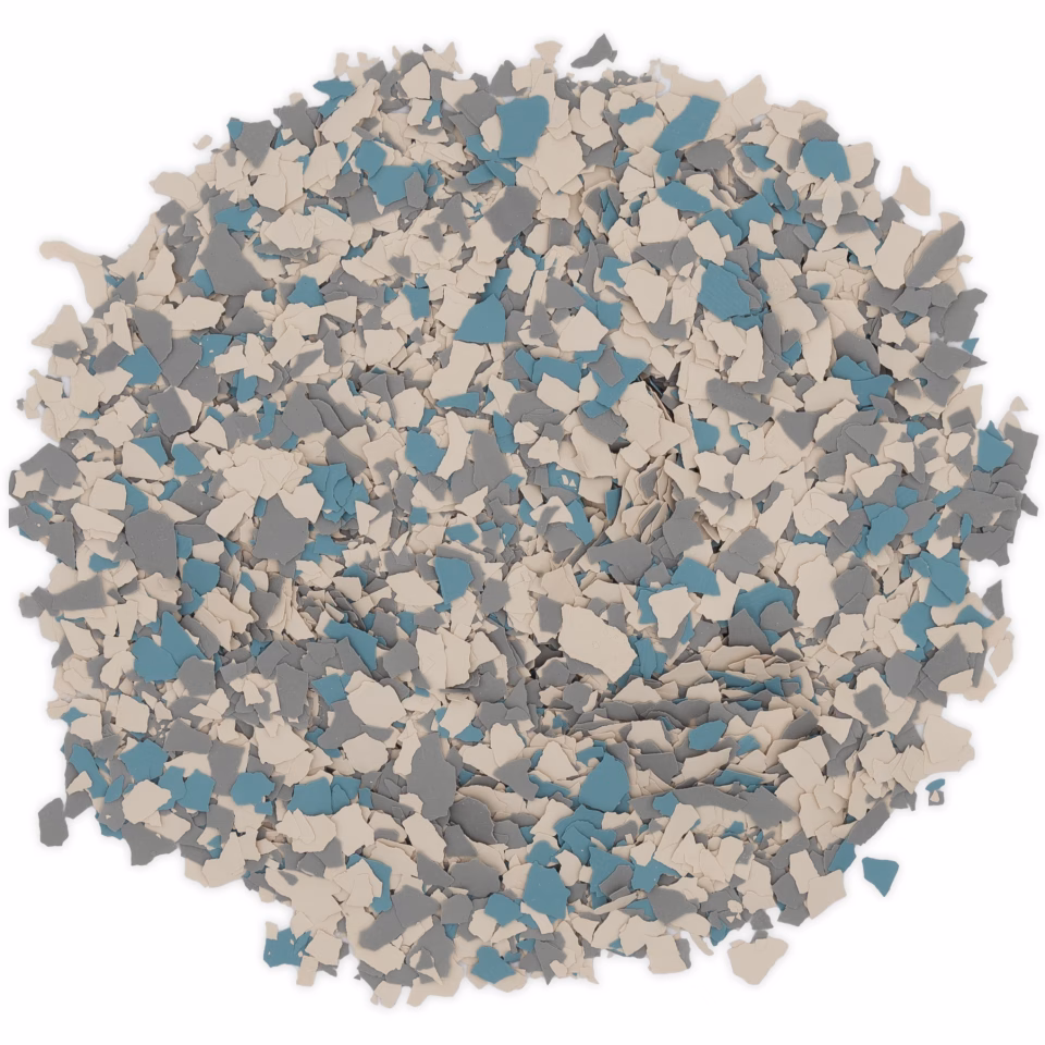 Close-up of a pile of small, irregular blue, gray, and beige paint flakes.