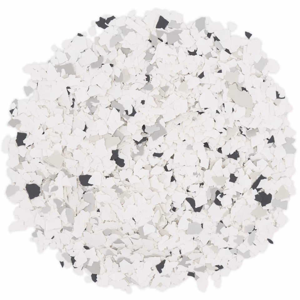Round pile of small white, gray, and black flakes on a white background.