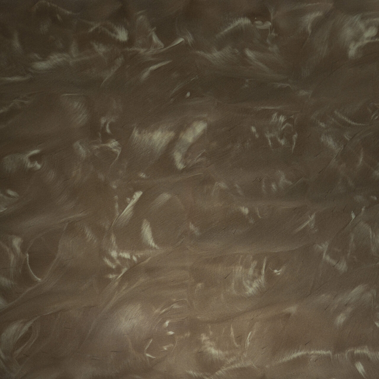 Circular pile of small multishaded gray and black flakes on white background.