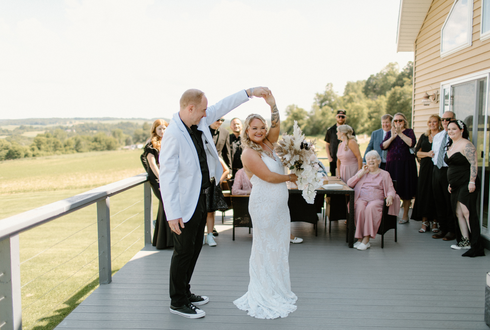 Newlyweds sharing their first dance on the farmhouse deck overlooking rolling New York farmland