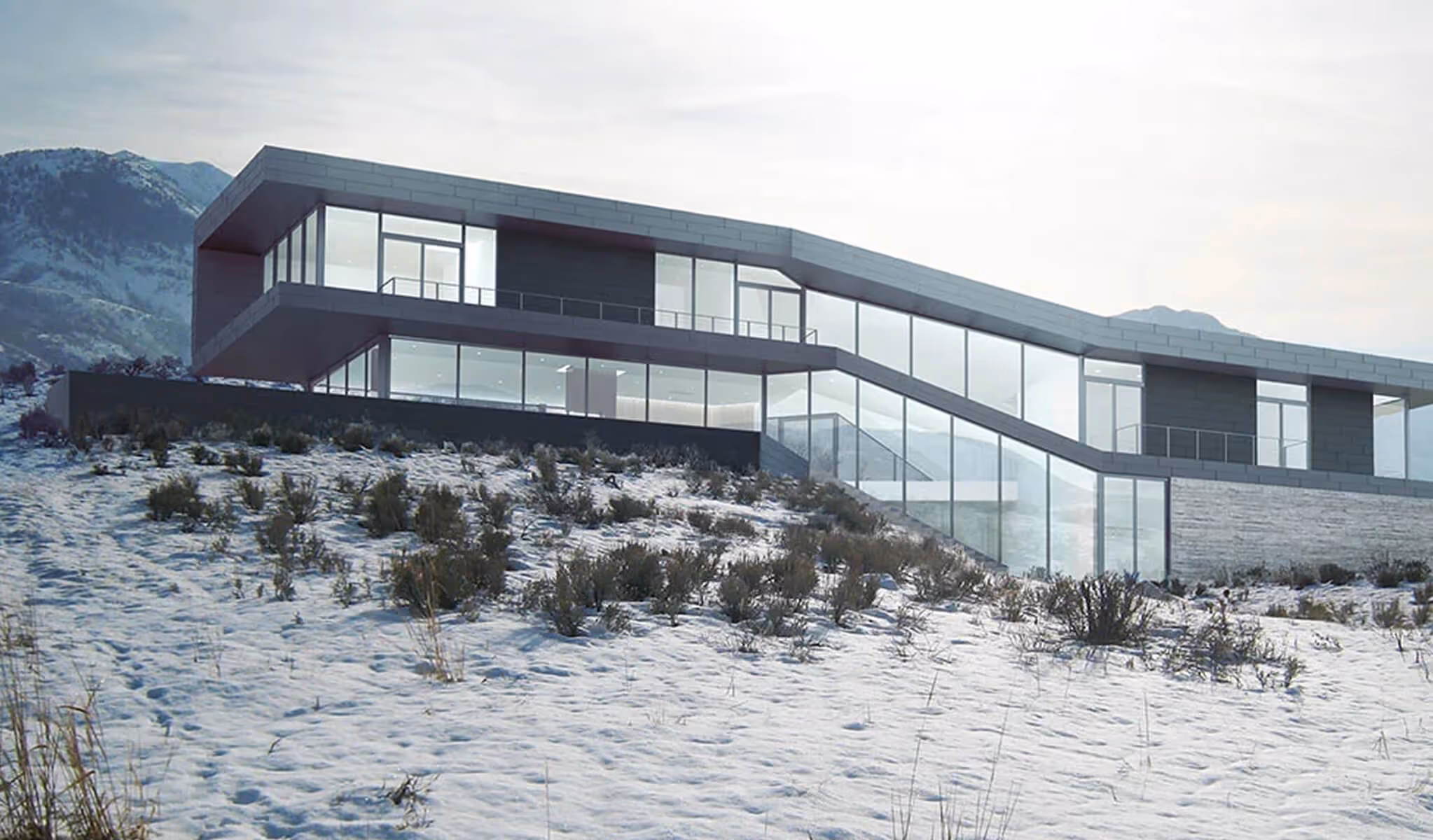 Modern house with large glass windows on a snowy hillside with mountains in the background.