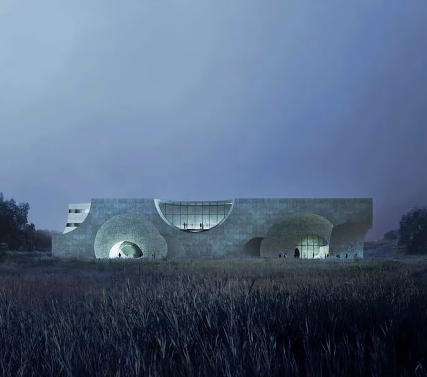 Modern building with large circular openings lit from inside, surrounded by tall grass at dusk.