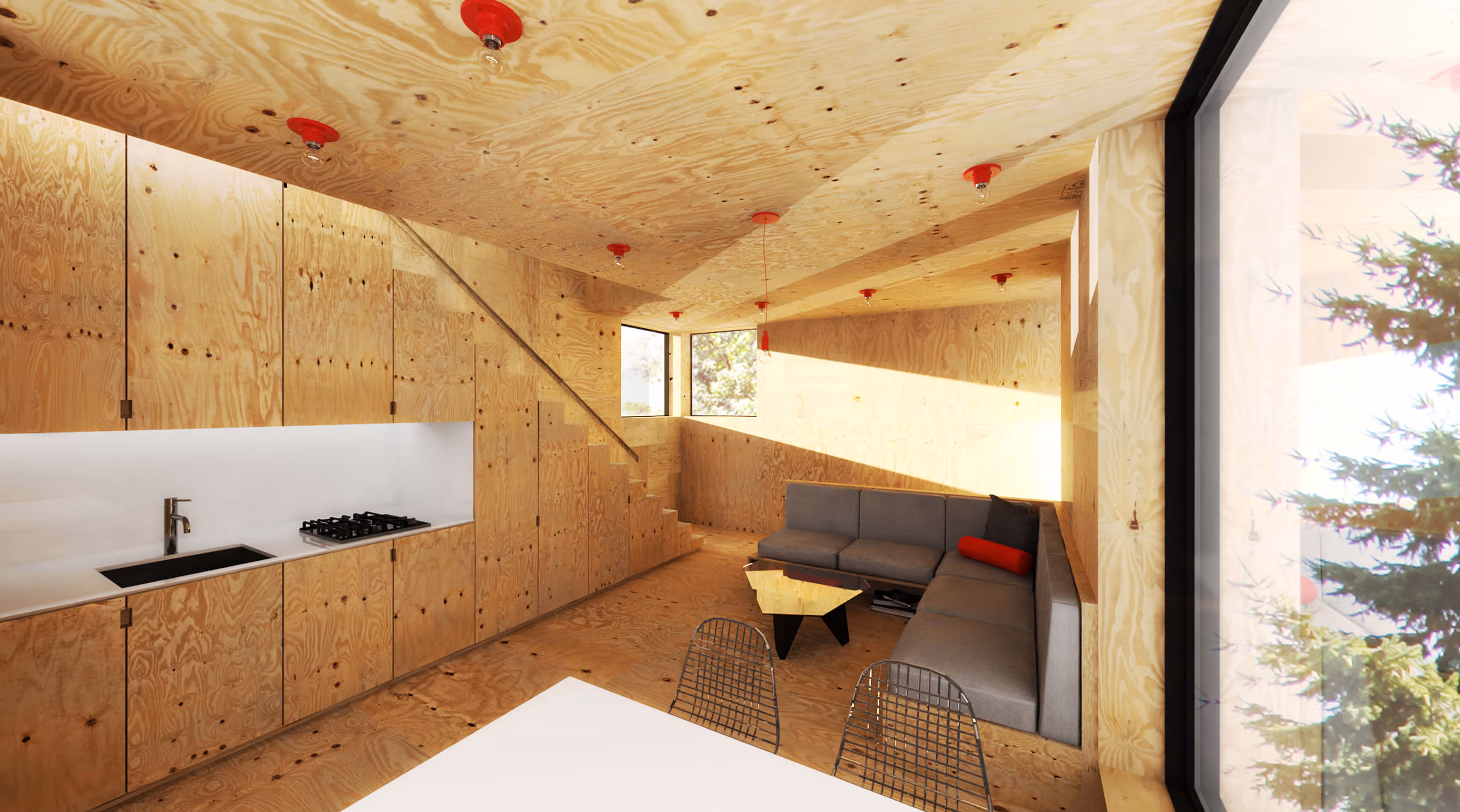 Compact living space with plywood walls, ceiling, and floor, gray sectional sofa, kitchen, and large window.