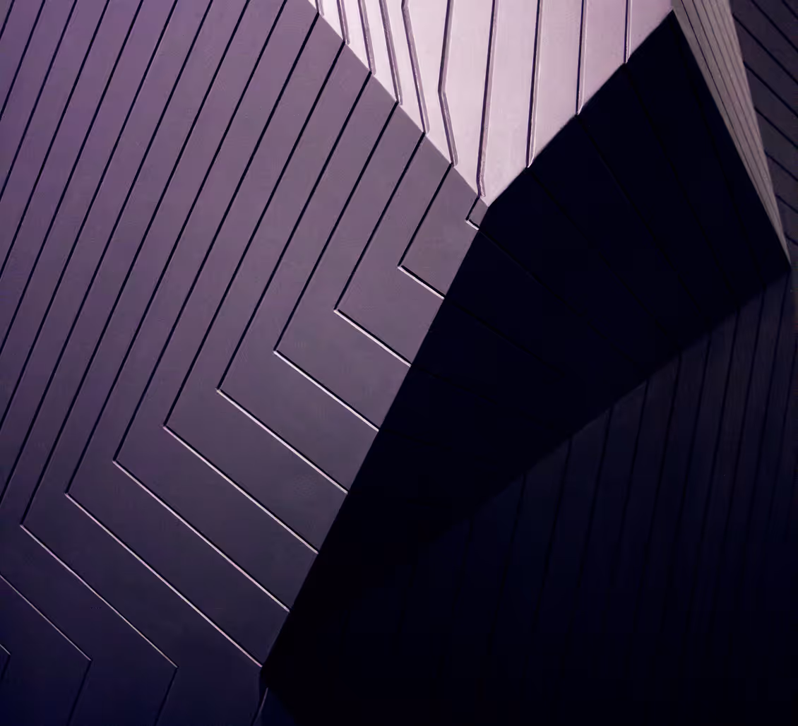 Abstract dark geometric architecture with diagonal and vertical lines creating angular shadows.