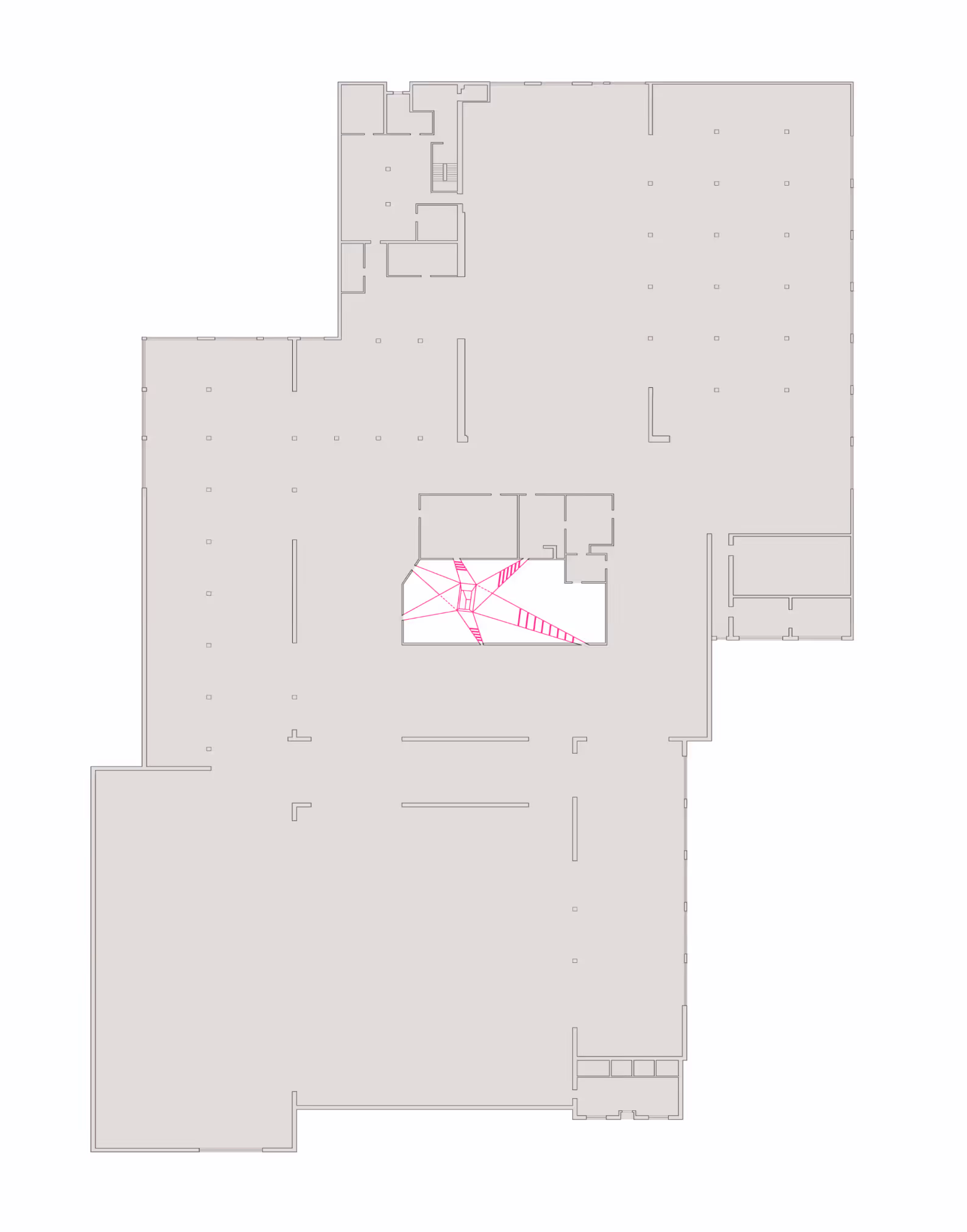 Floor plan of a large building with interior walls and pink geometric lines in the center space.