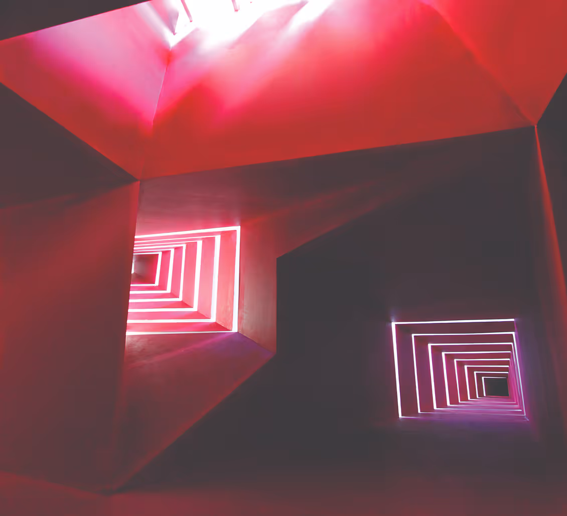 Abstract ceiling with glowing pink and purple square light patterns and sharp angular shadows.