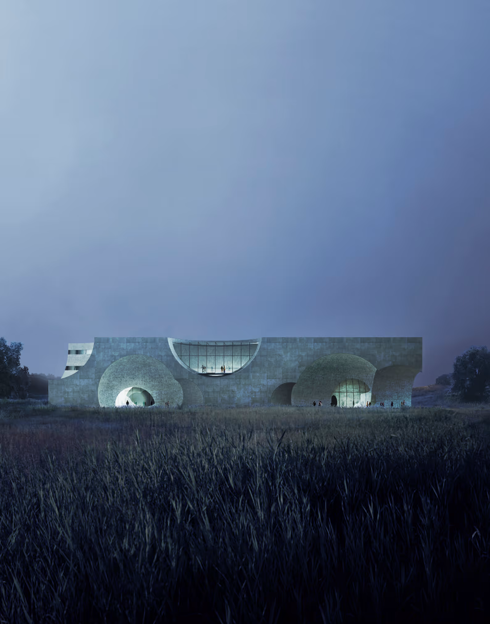 Modern building with large circular windows lit from inside, set behind tall grass at dusk.