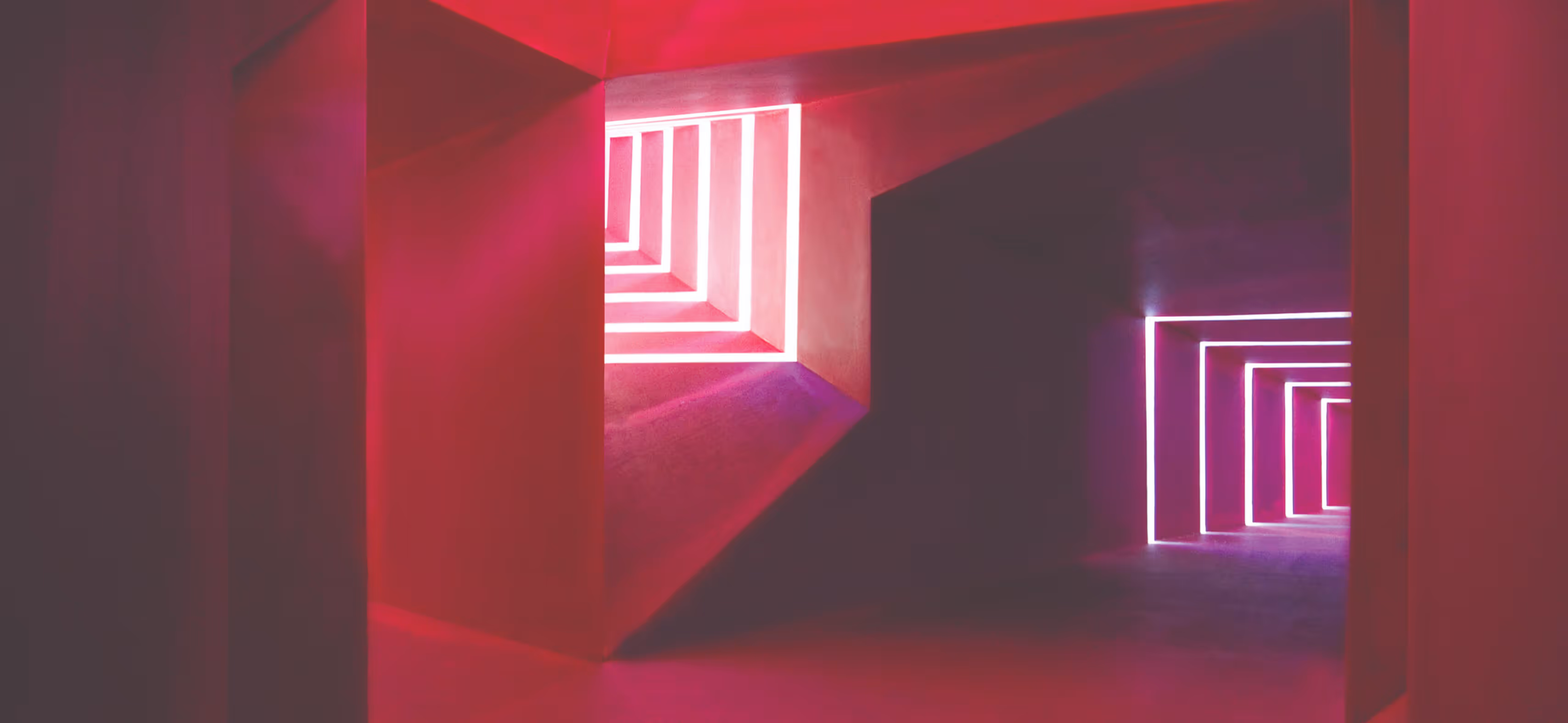Geometric hallway with pink and purple neon square frames creating a tunnel effect.