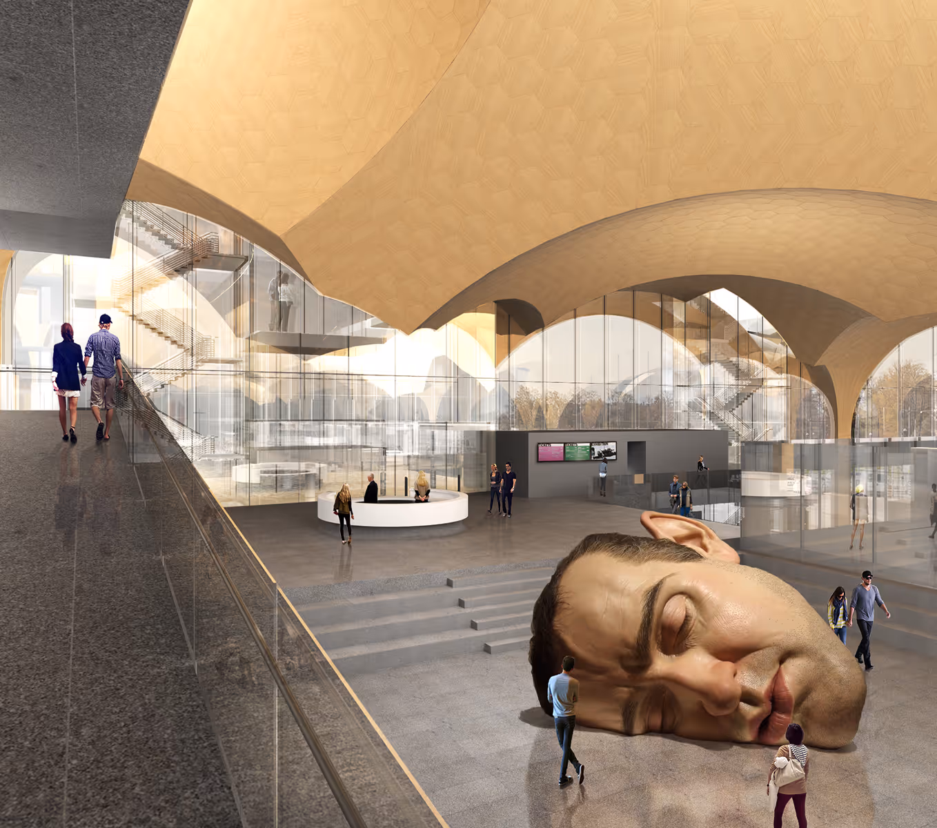 Futuristic interior with curved ceiling featuring a giant sleeping head sculpture on the floor and people walking nearby.