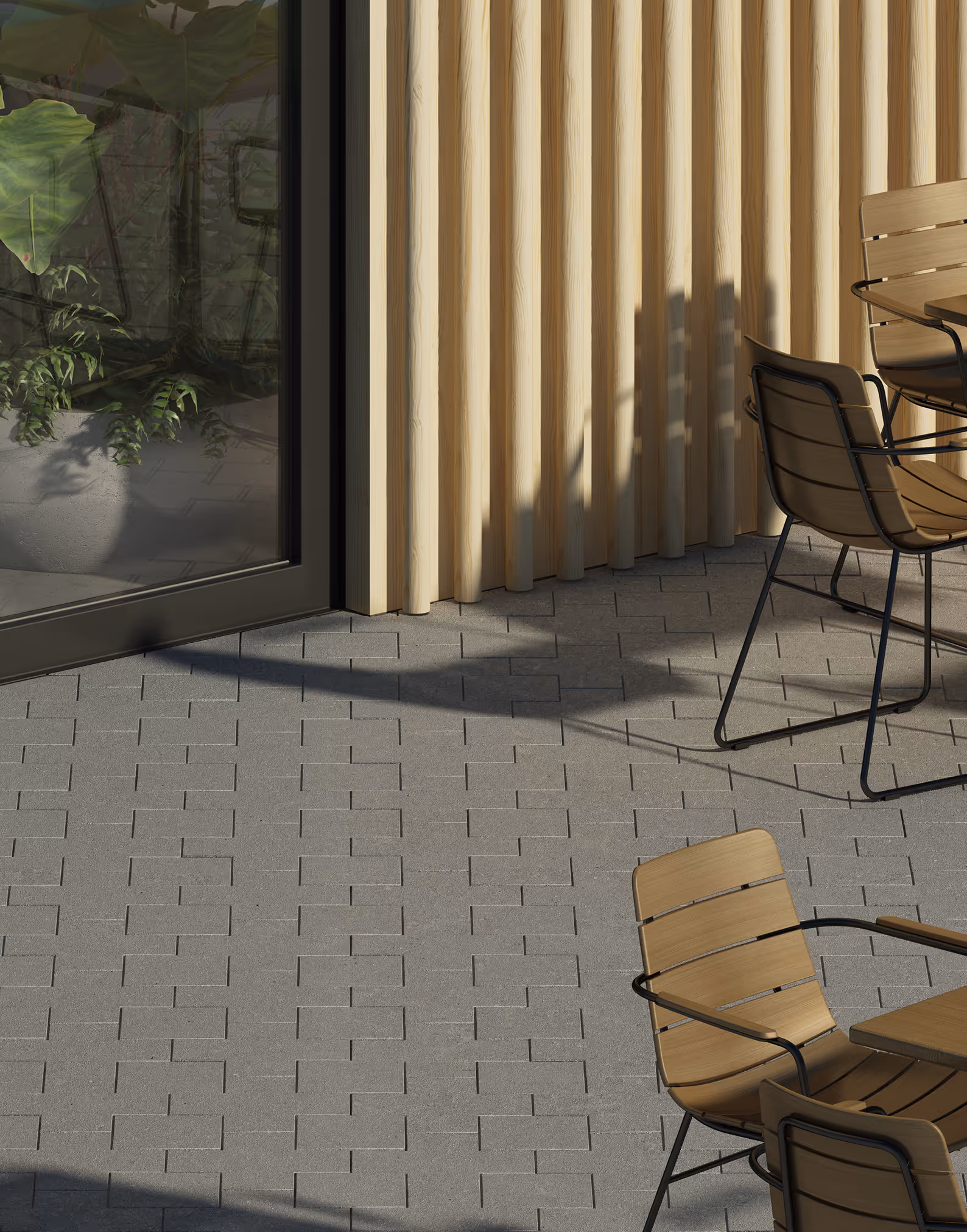Wooden chairs with black metal frames around tables on gray tiled patio next to glass door and wooden wall.