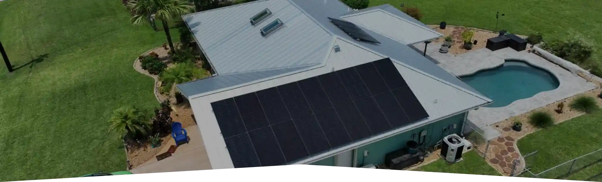 Solar panels and battery backup on home with metal roof and a pool in Orlando