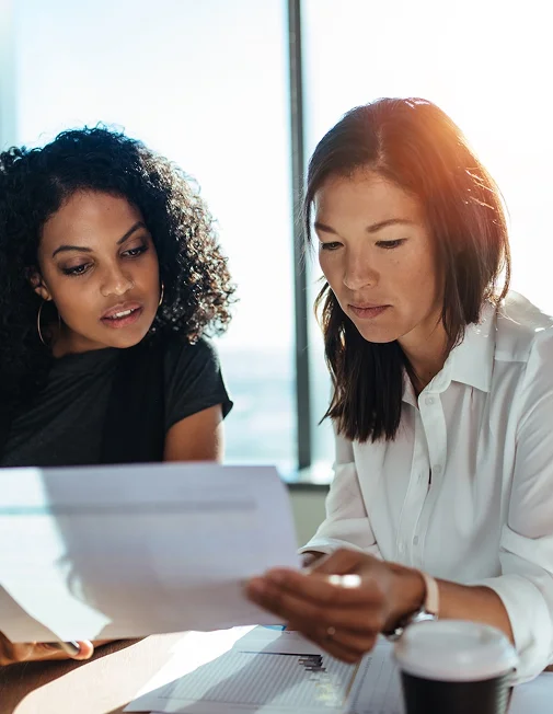2 women reading a document in an office