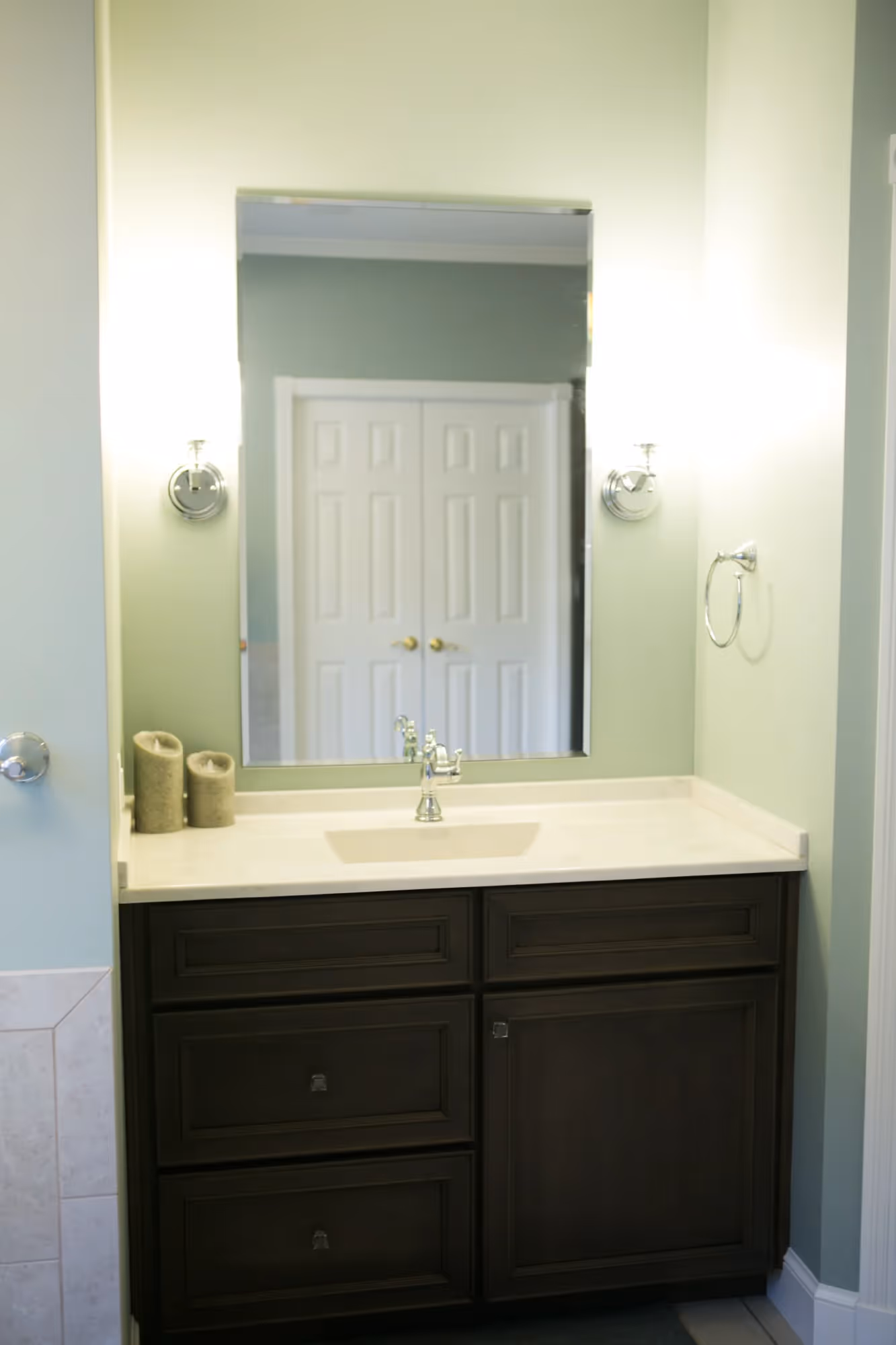 Bathroom vanity with sink and large mirror.