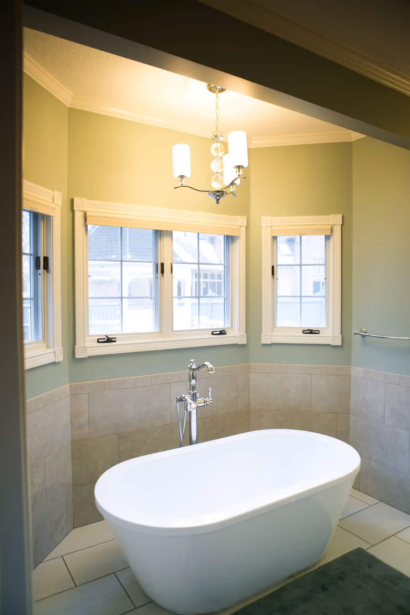 White bathtub beside a window with natural light.