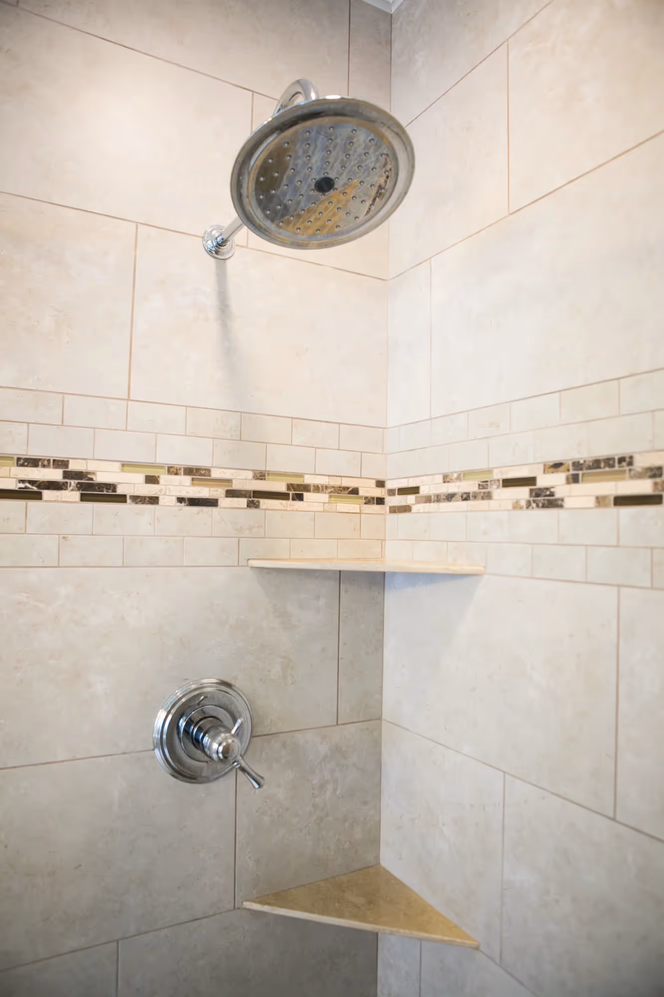 Close-up of a tiled shower wall with built-in shelf.