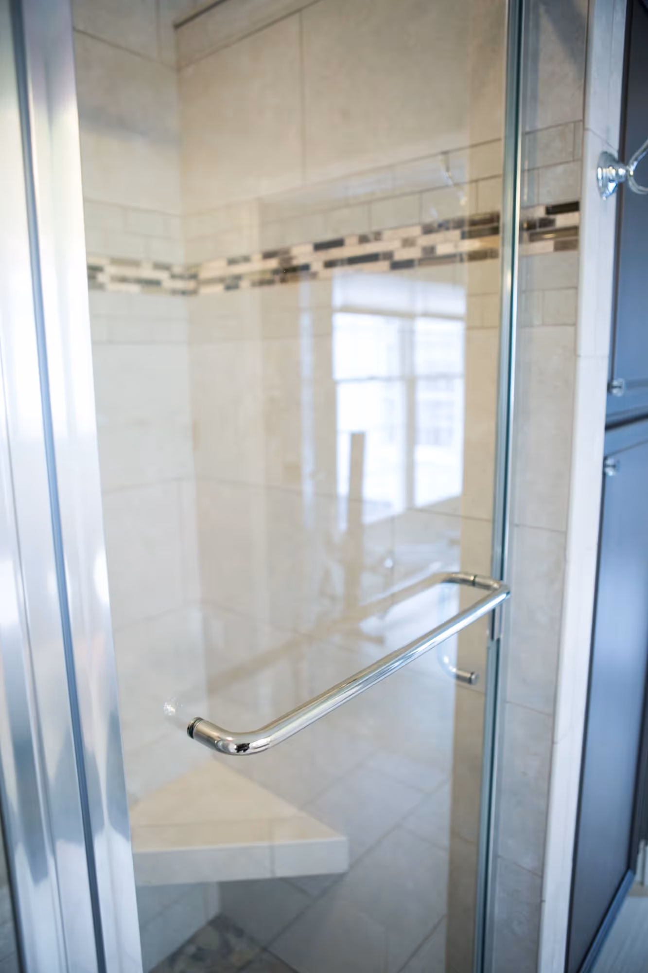 Walk-in shower and white vanity in a bright bathroom.