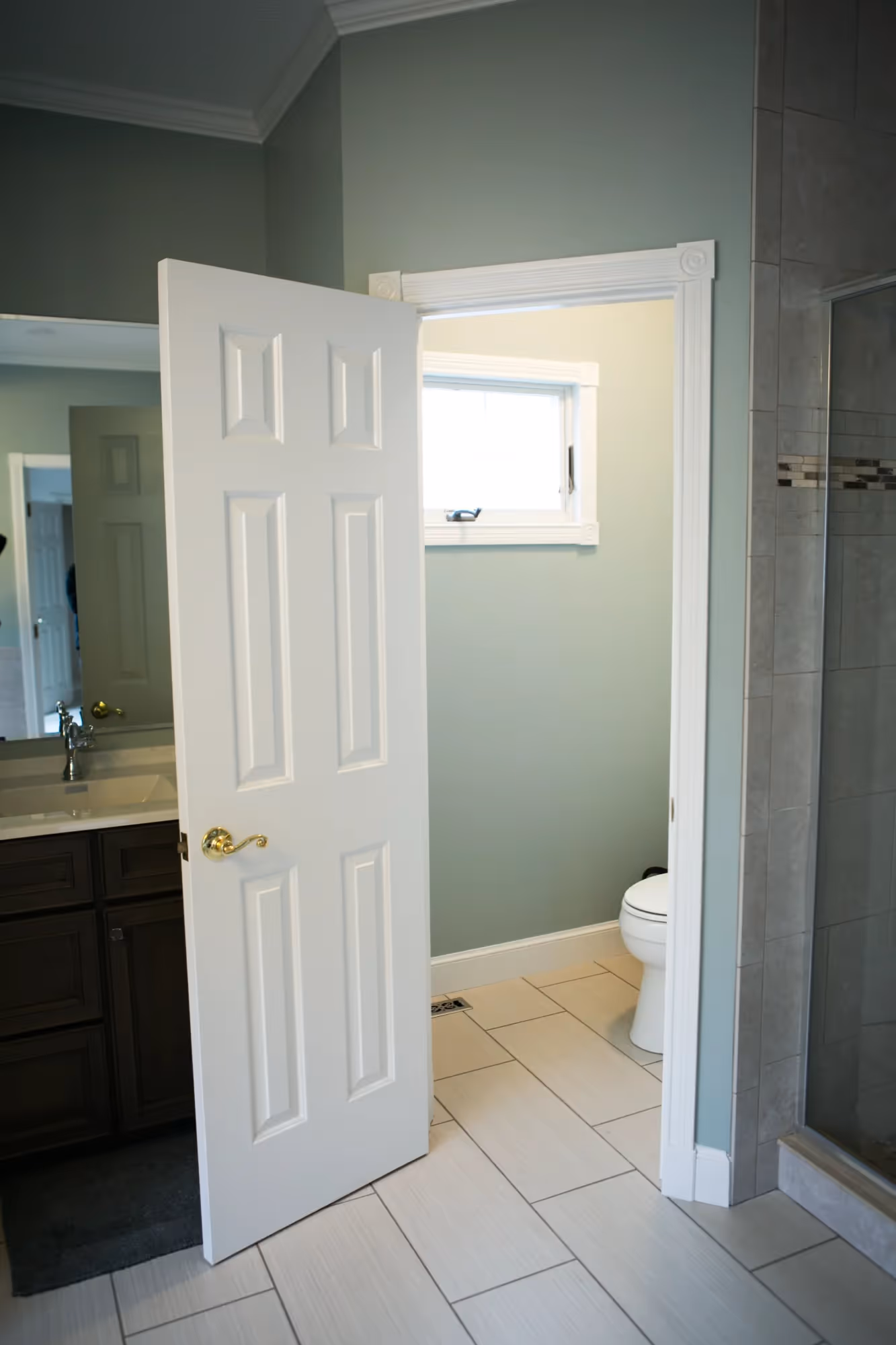 Shower area with glass door and tiled walls.