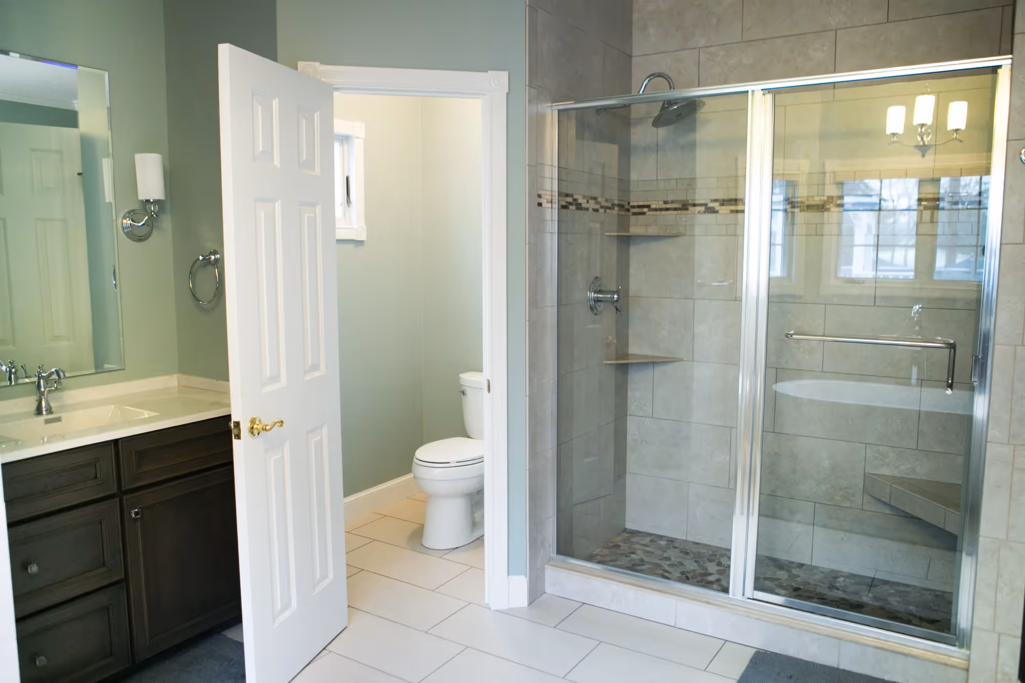 Spacious bathroom with glass shower enclosure and vanity.