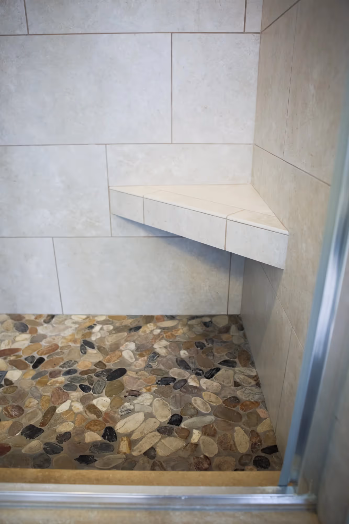 Shower area with tiled walls and built-in corner shelf.