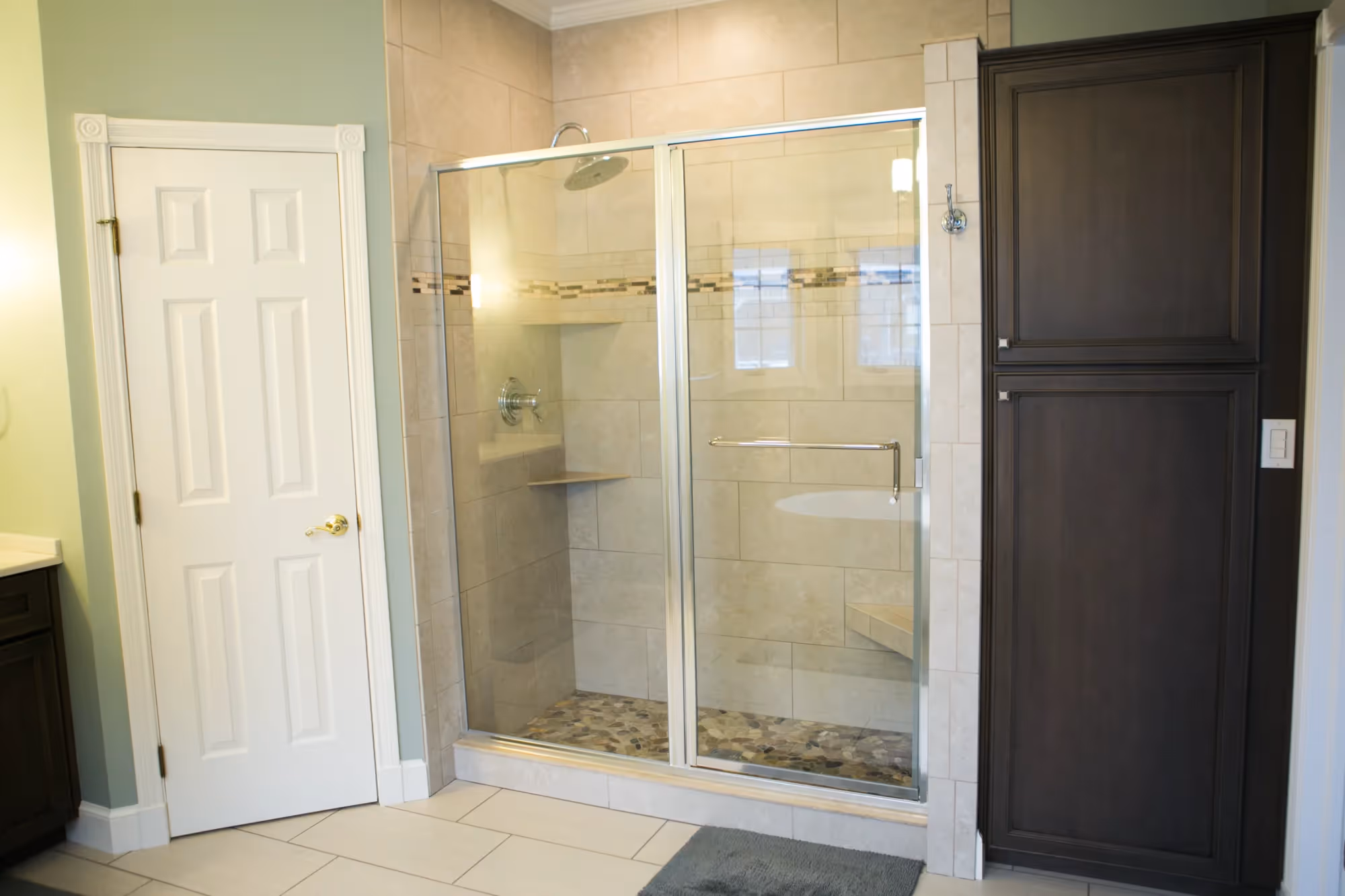 Bathroom with a glass shower, bathtub, and double doors.