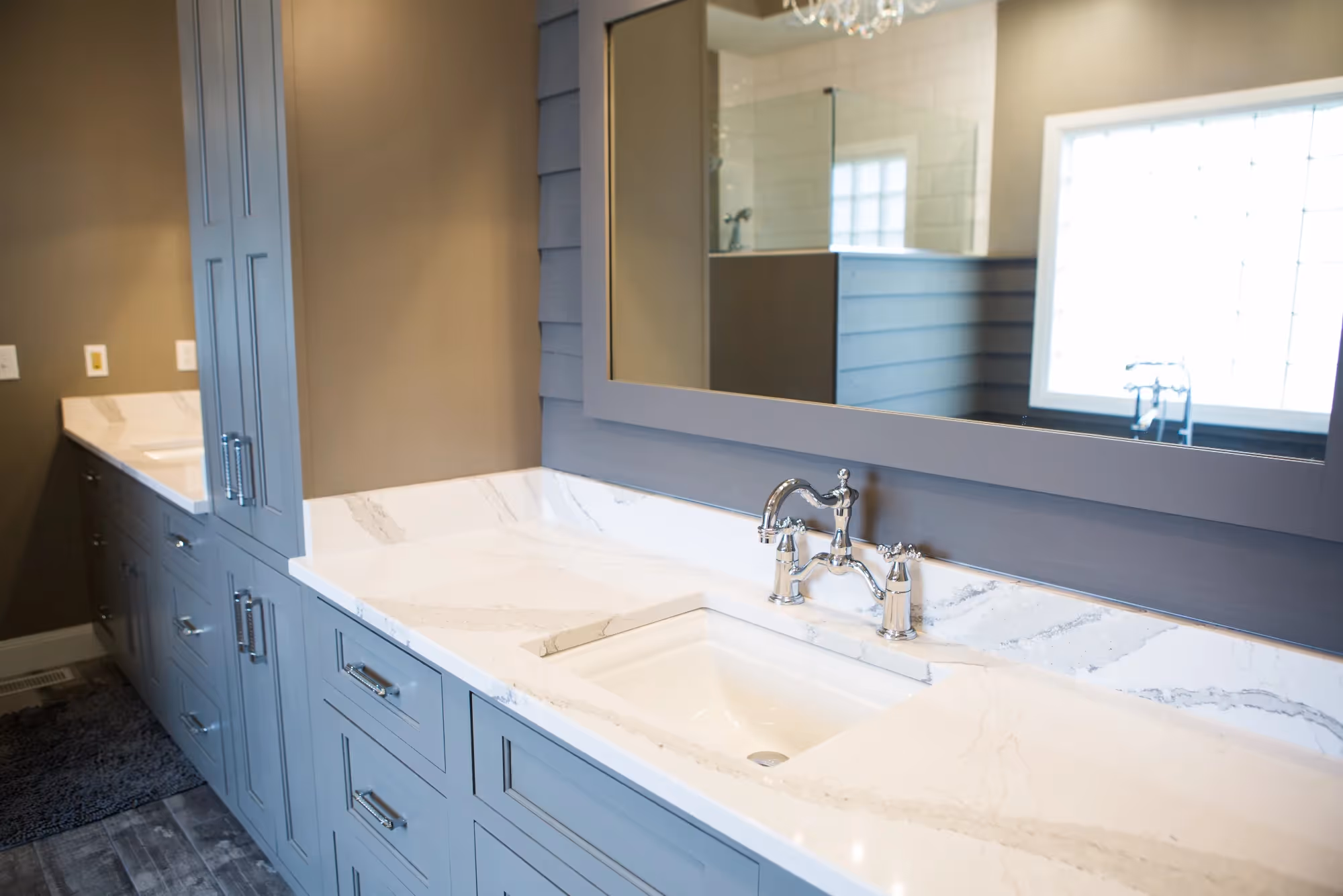 Double vanity bathroom with large mirror and dark cabinetry